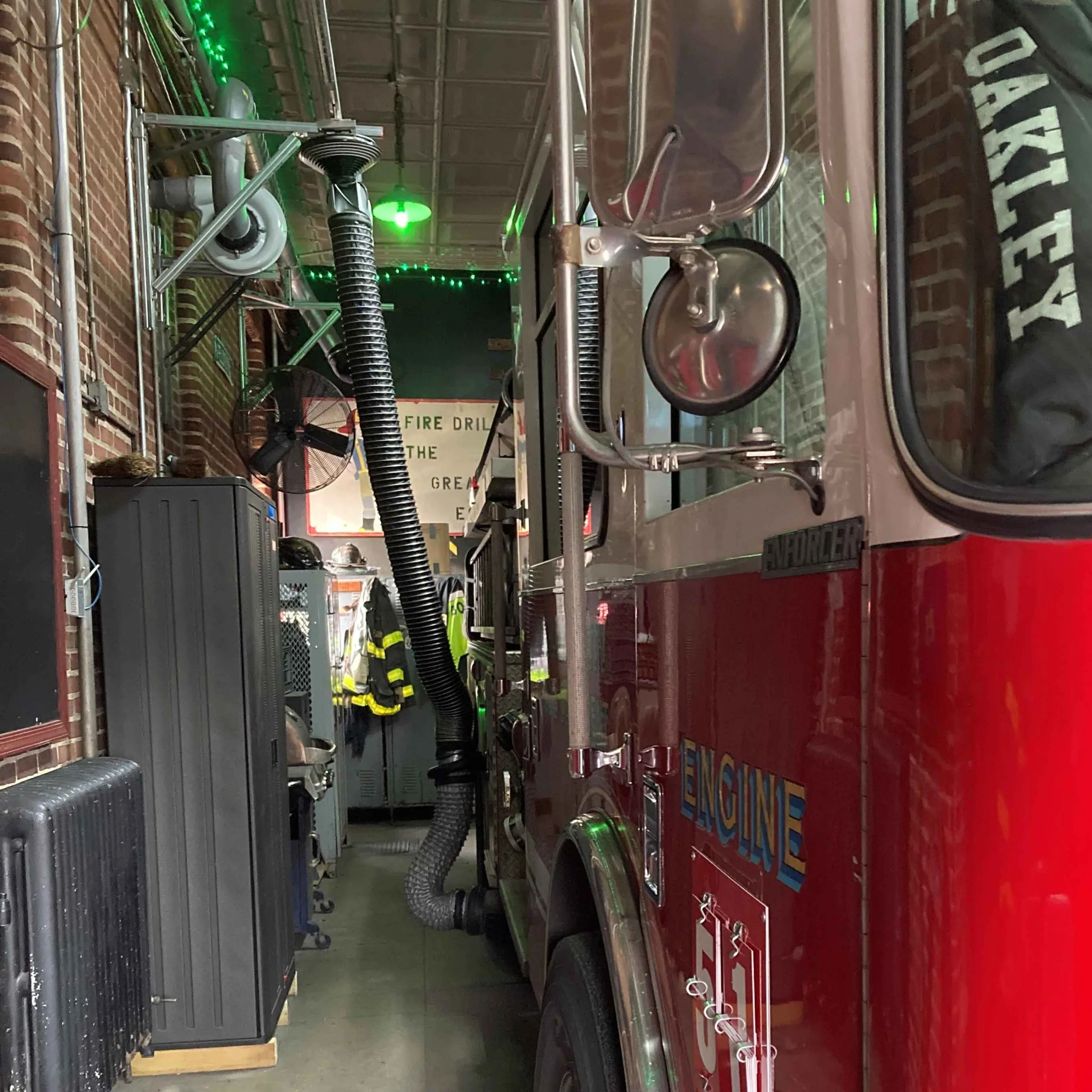 View down from front down the side of fire truck connected to exhaust hose